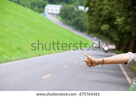 Woman is making sign hitchhiking car