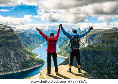 Couple standing against amazing nature view on the way to Trolltunga. Location: Scandinavian Mountains, Norway, Stavanger. Artistic picture. Beauty world. The feeling of complete freedom