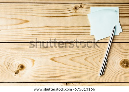 Sticker with metal pen on a wooden table, office concept