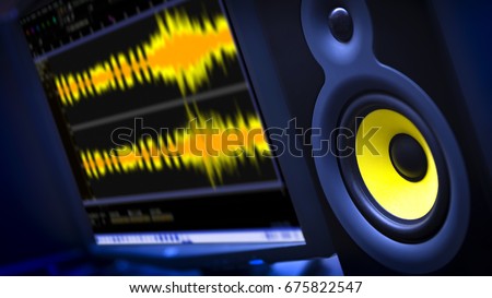 Audio Editing Computer with studio monitor speaker and waveform displayed on monitor.  Shallow Depth of Field with focus on speaker.