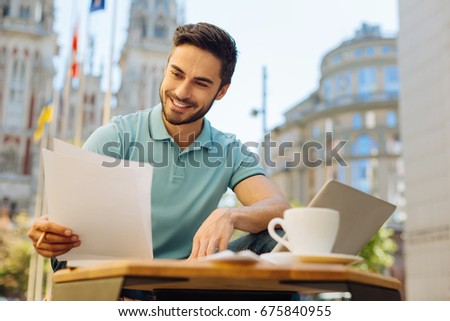 Committed handsome man reading the documents carefully
