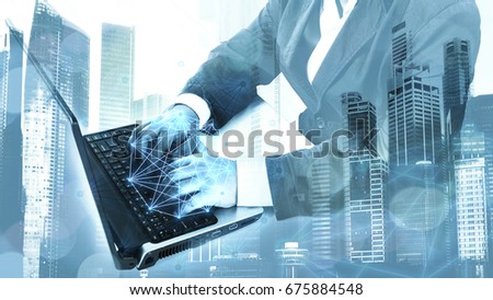 Double exposure of success businessman using Laptop/notebook with city landscape background. Mixed media. concept of telecommunication with network line.