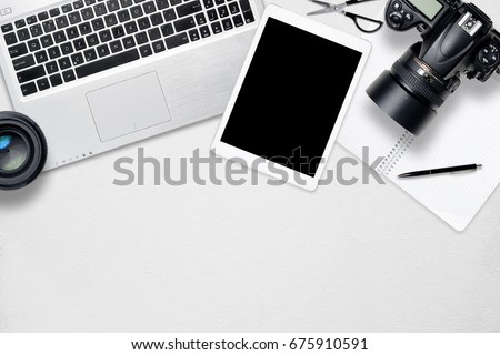 White office photography desk table with laptop, tablet, camera and glass. Top view with copy space