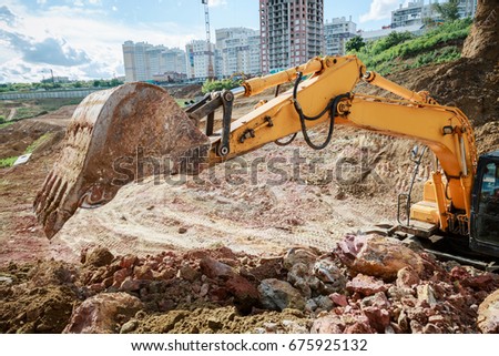 Excavator work on the construction site. The bucket lifted up.