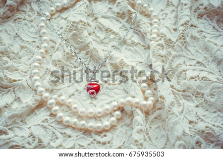 Vintage tenderness wedding accessories. Stylish colorful red jewelry with stones on a white lace. 