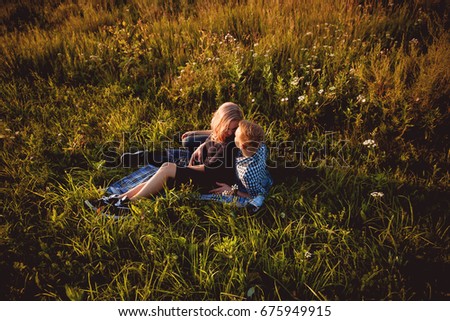 Beautiful loving couple lies in the field on plaid