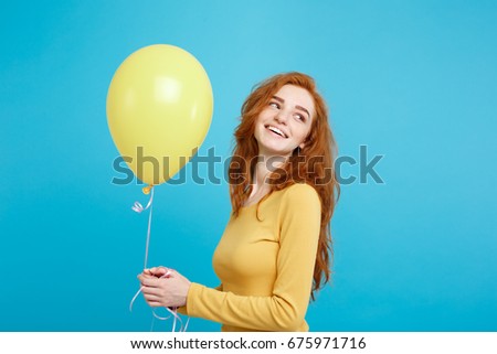 Close up Portrait happy young beautiful attractive redhair girl smiling with colorful party balloon. Blue Pastel Background.
