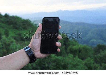 Left hand use phone on mountain view.hand of technology