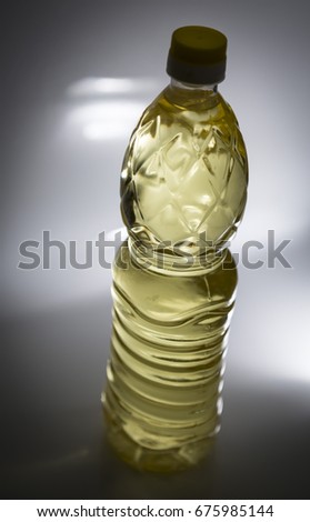 Plastic bottle of oil with yellow lid - dark environment with moody lighting 