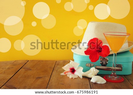 Fedora hat, tropical hibiscus flower on wooden table. relaxation or vacation concept.