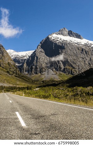 Scenic road towards a snow-capped peak near to Milford Sound, New Zealand.