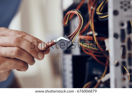Technician-programmer repairs computer wires                               