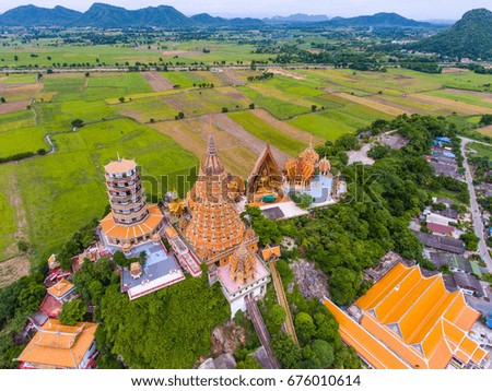 Aerial view of beautiful temple on the top of mountain with green rice paddy background