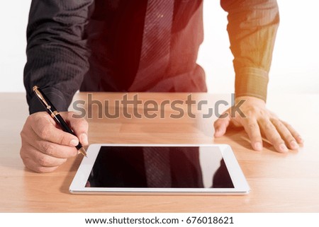 businessman using tablet on working wooden table