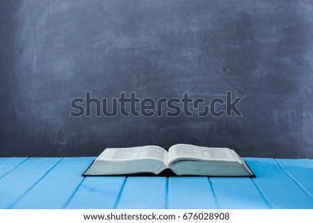 Bible and the crucifix on a blue wooden table. Beautiful background.Religion concept
