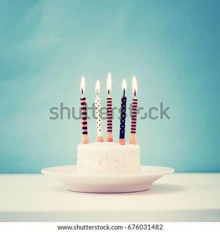 Birthday white cake with colorful candles in vintage color 