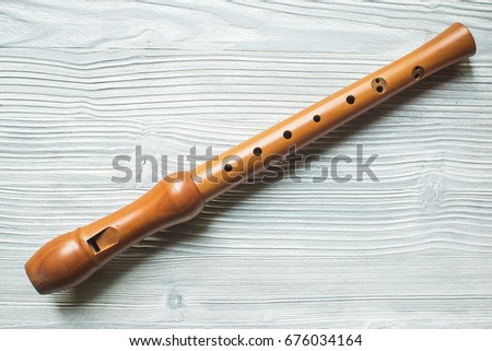 Wood block flute on white wood background Royalty-Free Stock Photo #676034164