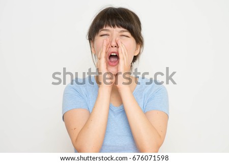 Portrait of pretty young beautiful woman loud screaming or calling out to someone, isolated over white background