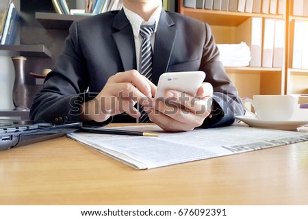 A man surfing internet for working new business online. Light and office work station background.