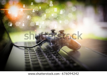 Video game controller isolated on the laptop concept Royalty-Free Stock Photo #676094242