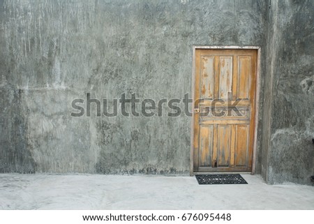 The wooden door on cement background