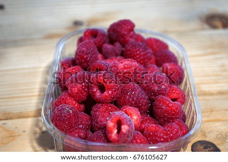 Raspberry in a bowl on a wooden table
