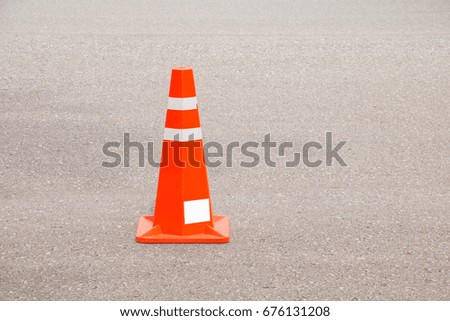 Traffic cone old orange and swath white stripes on the road with copy space