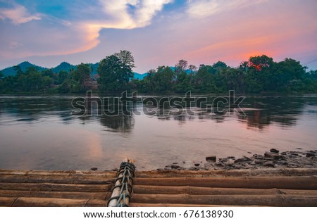 Scenic view of beautiful sky and cloud. forest and mountain over flow river in the spring. With rocks and Wooden raft in foreground. Hellfire Pass, kwai noi, Kanchanaburi, Thailand