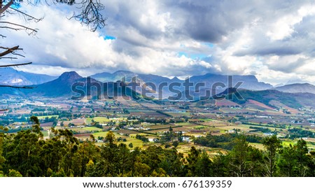 Franschhoek Valley in the Western Cape of South Africa with its many vineyards as seen from Franschhoek Pass in the Middagskransberg between the Franschhoek Valley and the Wemmershoek Mountains Royalty-Free Stock Photo #676139359