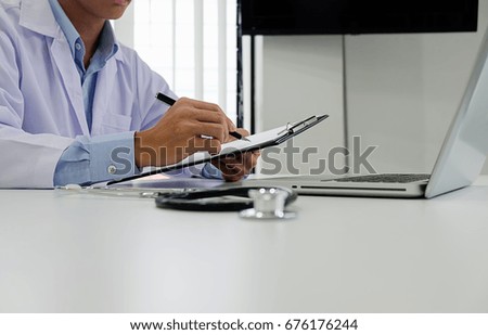Stethoscope with clipboard and Laptop on desk, Doctor working in hospital writing a prescription, Healthcare and medical concept, test results in background, vintage color, selective focus. 