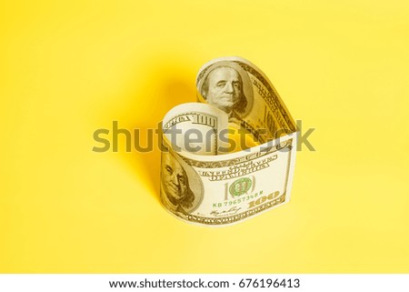 Hundred dollar bill in heart shape