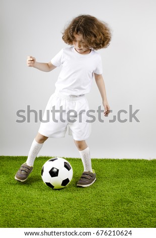 Boy with soccer ball on the green grass. 