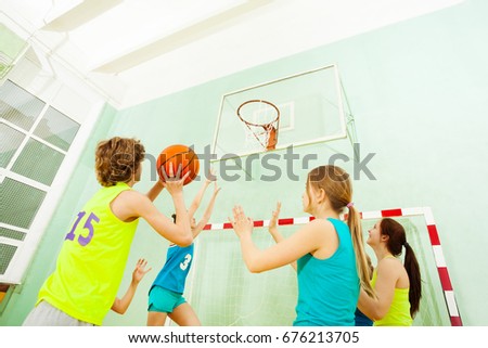 Basketball match with girls defending against boy