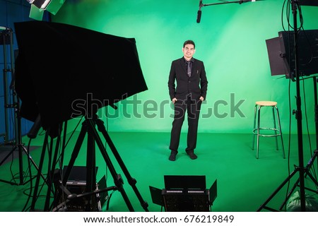 Business man standing up in front of the camera in television studio , Business man presenter in television Studio