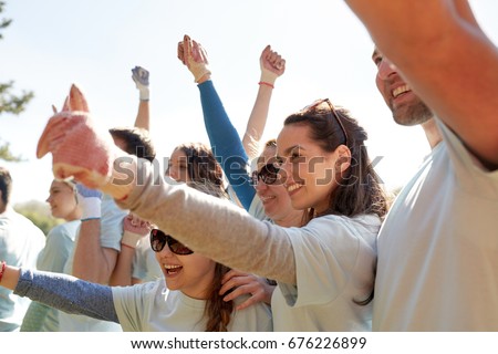 volunteering, charity and people concept - group of happy volunteers celebrating success up in park Royalty-Free Stock Photo #676226899