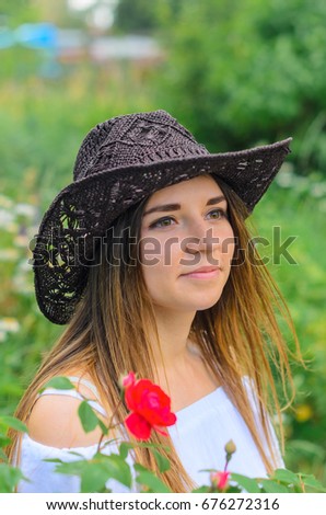 the young girl walks on the ranch. the slender girl in jeans and a cowboy's hat, a close up, macro. good skin