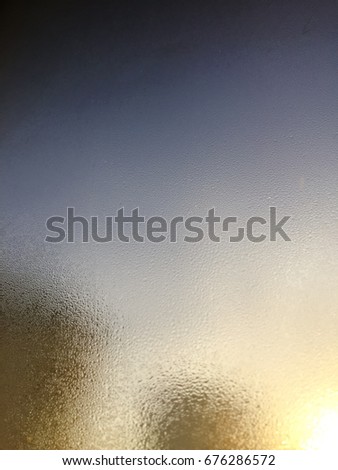 Blurred water drops on natural wet window abstract sunlight background. Close up photography of changing weather climate environment