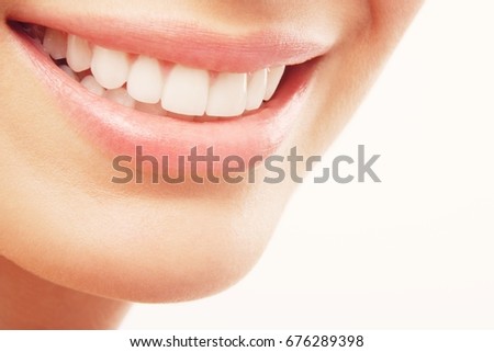Closeup of woman smiling with prefect white teeth on white background Royalty-Free Stock Photo #676289398