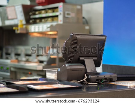 Cash and order desk and kitchen equipment on back in fast food restaurant