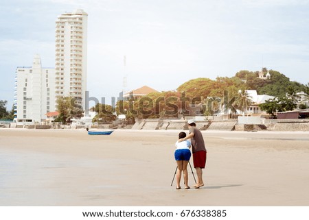 Couple taking picture using tripod on the beach on vacation