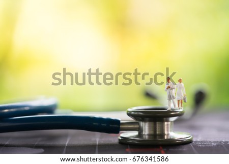 Miniature people, emergency medical team on stethoscope on world map. Health care and life insurance concept.