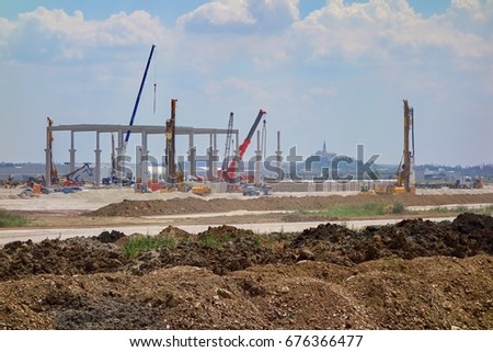 NITRA, SLOVAKIA, EUROPE - 8TH JULY 2017: Industrial Park - Construction of a new automotive factory, construction work and machinery. In the background city of Nitra.