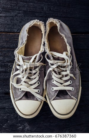 old sneakers on black wooden background