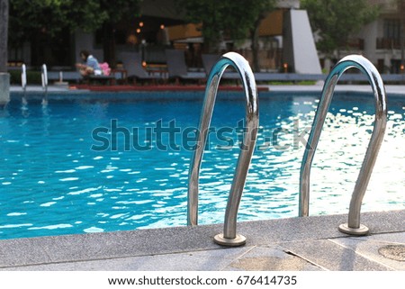 swimming pool with staircase.stainless steel ladder and swimming pool.selective focus.