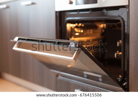 Empty open electric oven with hot air ventilation. New oven. Door is open and light is on Royalty-Free Stock Photo #676415506