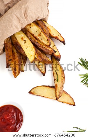 Slices of baked potato with rosemary and ketchup on a white background.
