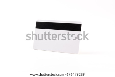 White blank credit card with black magnetic stripe on white background.