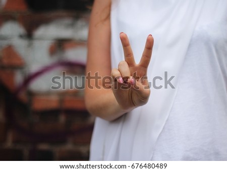 Young woman's hand shows V sign. Gesture.
