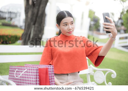 Young asian woman using smartphone for selfie alone.