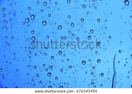 Rain drops on glass windows.The water on blue background.texture,copy space